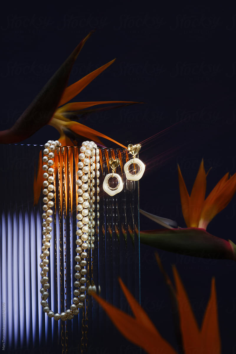 Fotografía de un reloj lujoso con un collar de piedras azules, sobre fondo azul oscuro